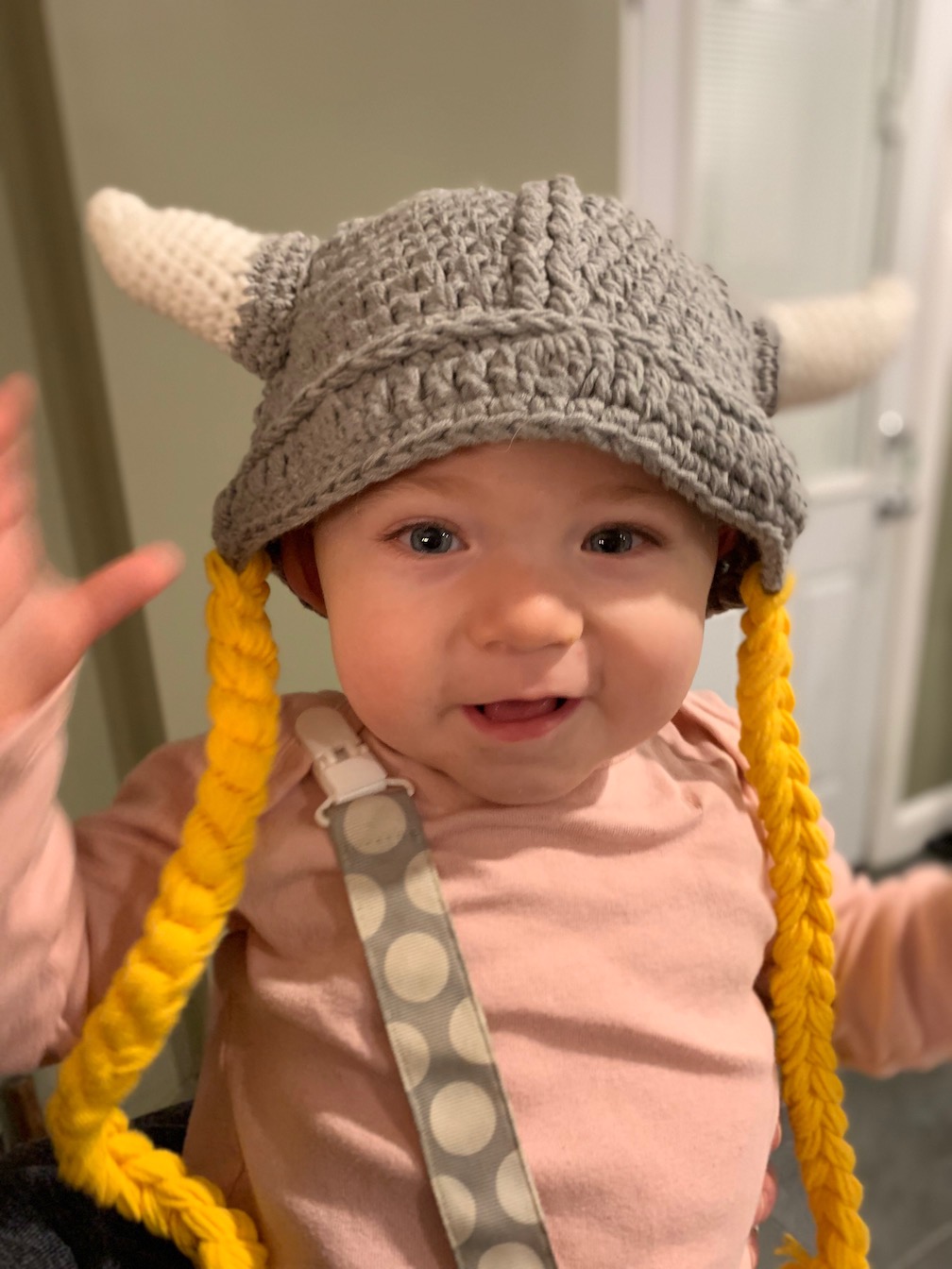 A young girl wearing a crochet Viking hat